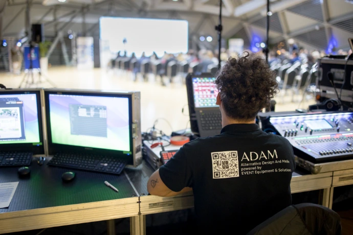 Rendezvénytechnikai vezérlőpult és operátor munka közben LED fal/AV háttérrel