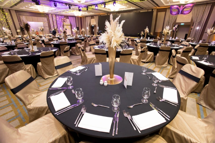 Elegáns gálavacsora körasztalokkal és díszítéssel egy rendezvényteremben
